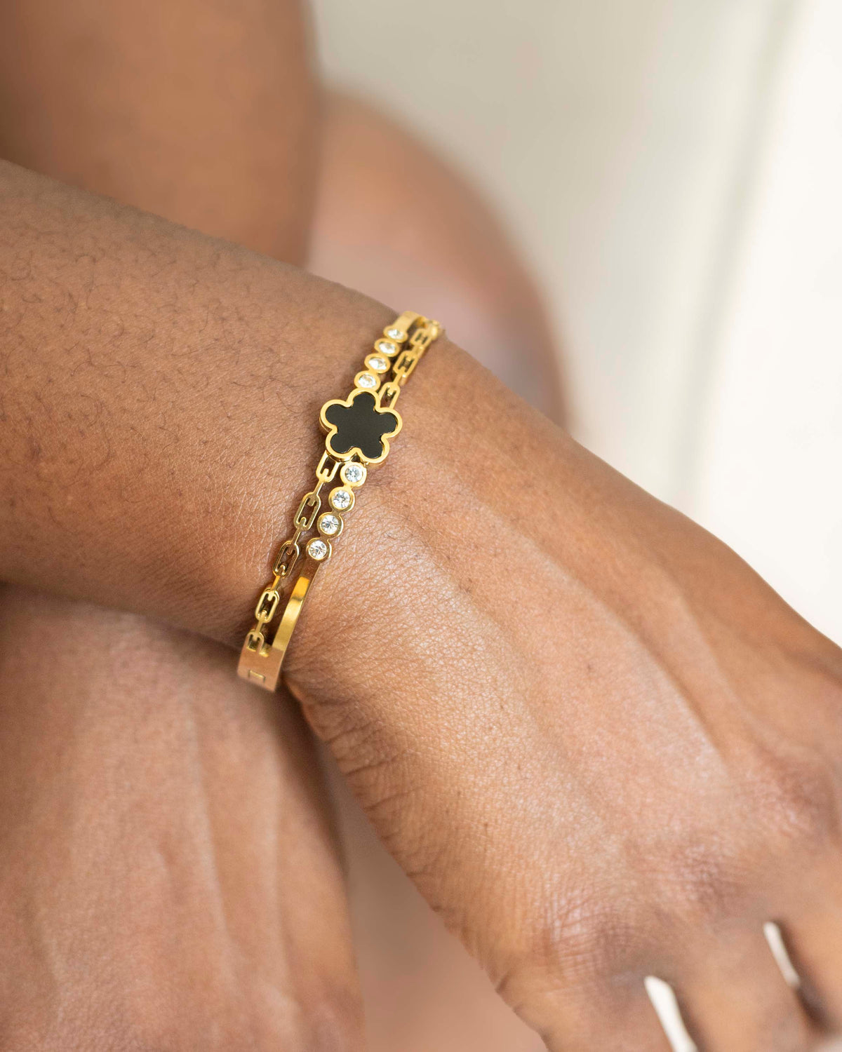 Model wearing 18K gold plated black clover crystal bangle bracelet — HYFN