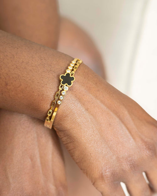 Model wearing 18K gold plated black clover crystal bangle bracelet — HYFN