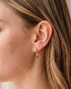 Model wearing 18K gold plated beaded hoop earrings with blue teardrop charm — HYFN