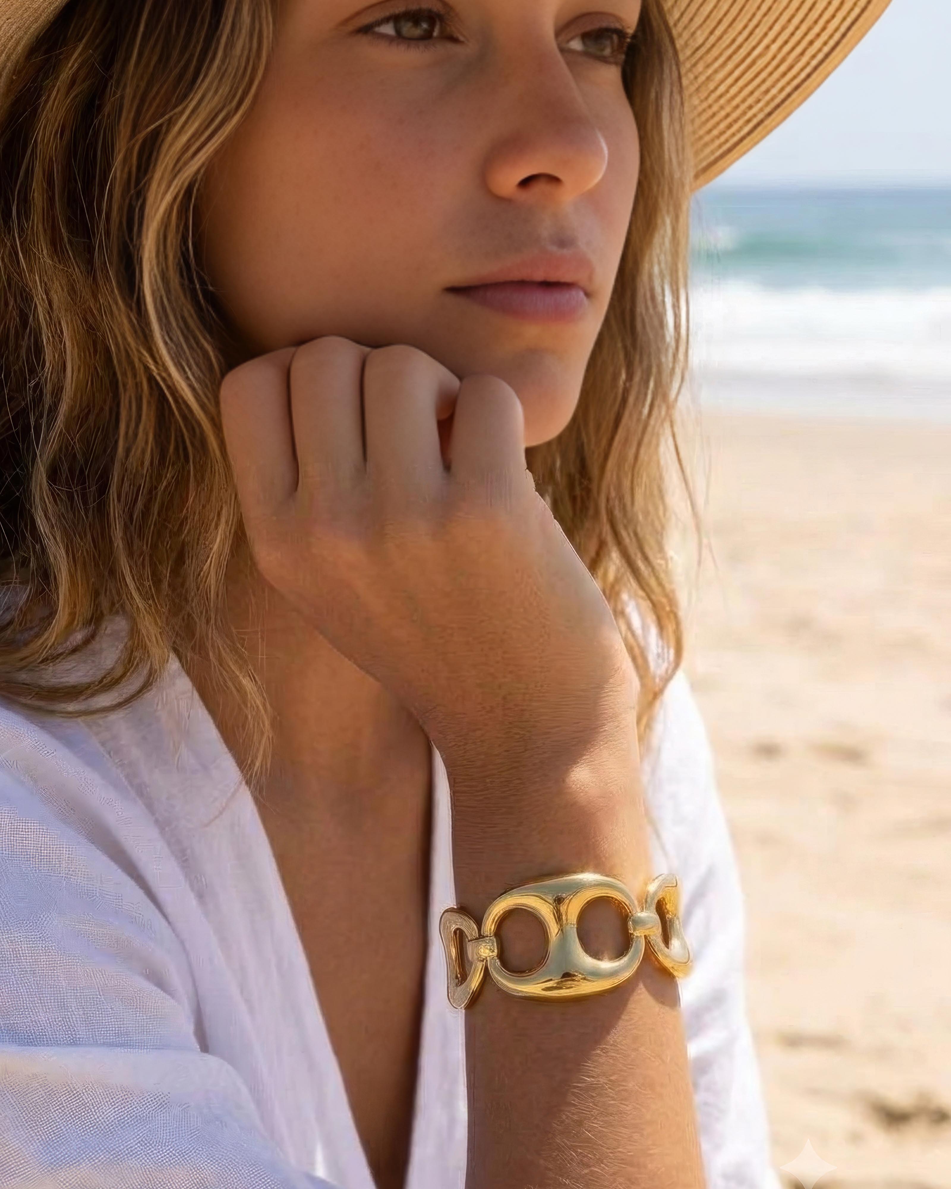 Model wearing 18K gold plated chunky sculpted link cuff bracelet on beach — HYFN